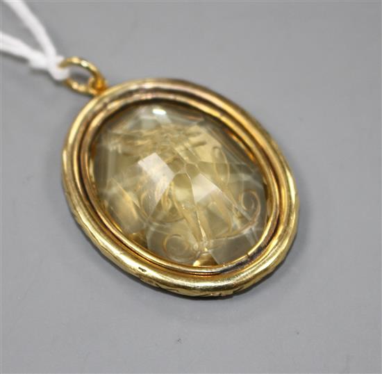 A late Victorian gilt metal mounted oval citrine pendant, engraved with a crested initial,